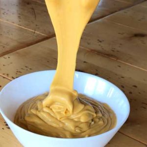 Pouring best vegan cheese sauce ever! Recipe for vegan cheese sauce without carrots or potatoes. Creamy and cheesy!
