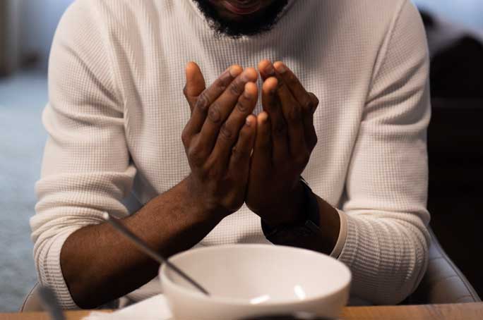 man holding hands over empty bowl giving thanks for food - mindful eating