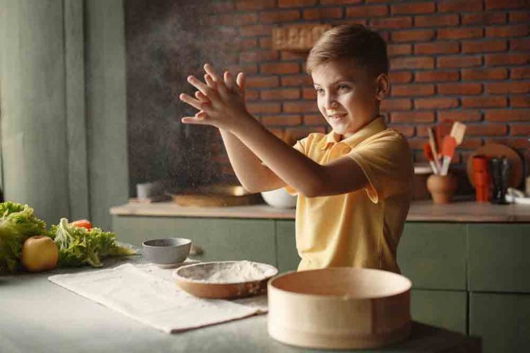 boy with flour - How to Teach Kids to Cook Vegan during Covid19. Let your kids help cook in the kitchen and teach them important life skills. Print this guide and kitchen activity book to help make working in the kitchen extra fun! Build on your skills and keep track of your progress.